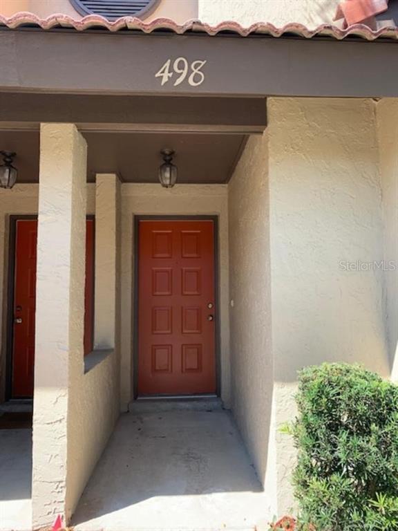 An exterior view of a residential entrance with a red door and house number 498 — 498 CLUB DRIVE, WINTER SPRINGS, FL