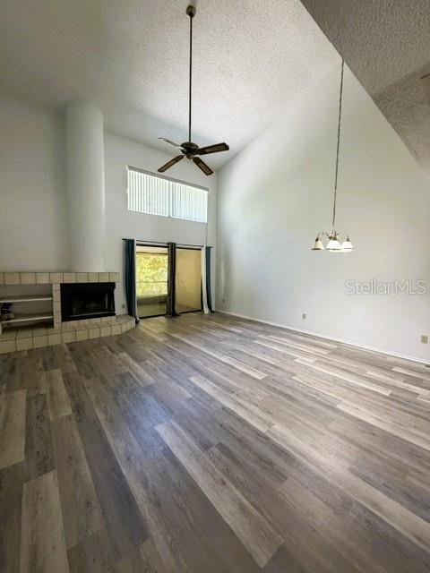 A living room features vaulted ceilings, a fireplace, a ceiling fan, and wood-look flooring — 498 CLUB DRIVE, WINTER SPRINGS, FL
