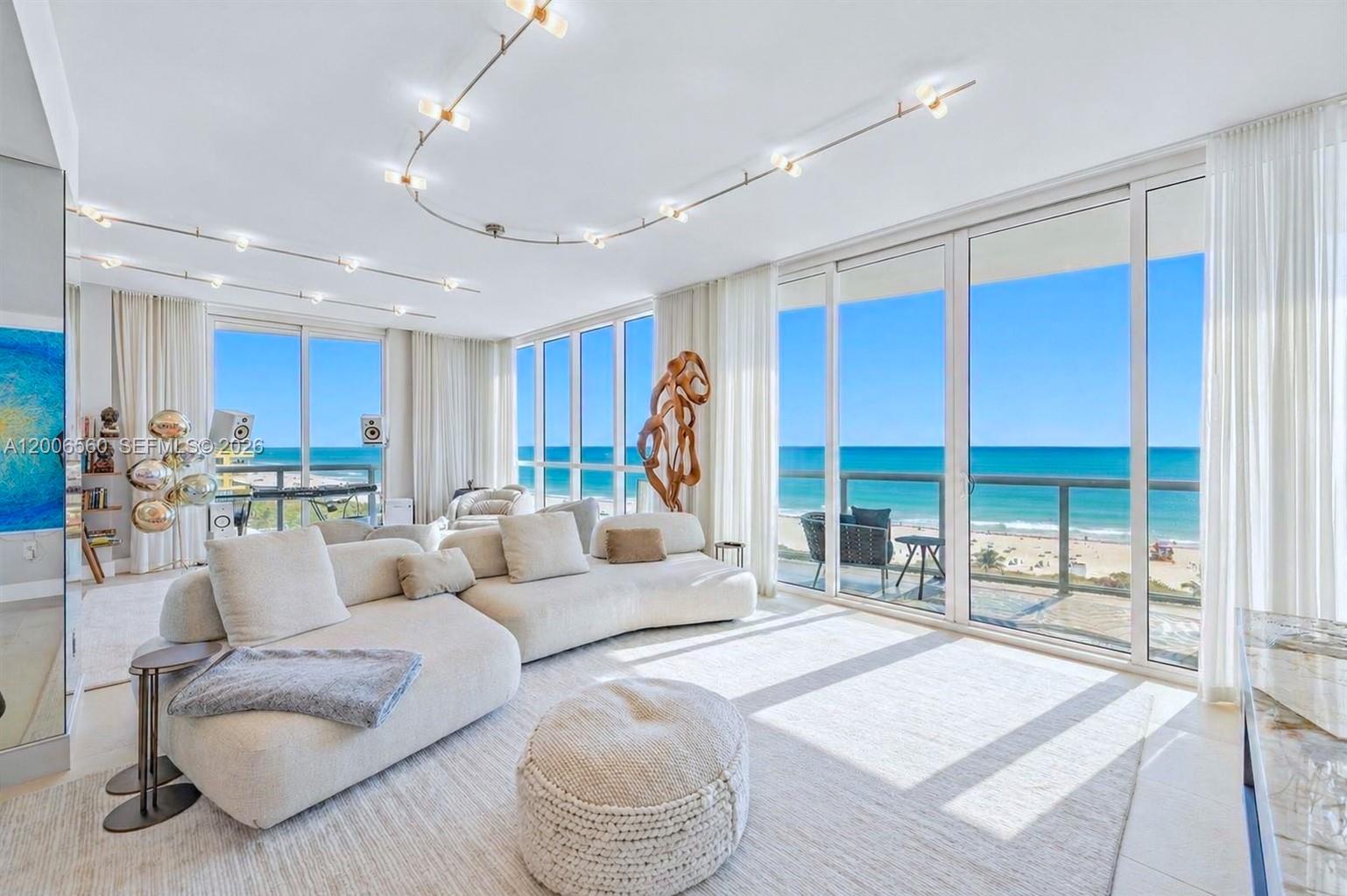 A bright living room features a curved sofa, track lighting, and floor-to-ceiling ocean views — 50 S Pointe Dr, Miami Beach FL 33139, MIAMI BEACH, FL