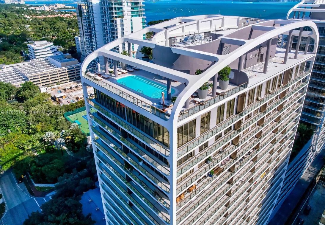 Aerial view of a modern high-rise building featuring a rooftop swimming pool and balconies — 2678 Tigertail # 1009, Miami FL 33133, MIAMI, FL