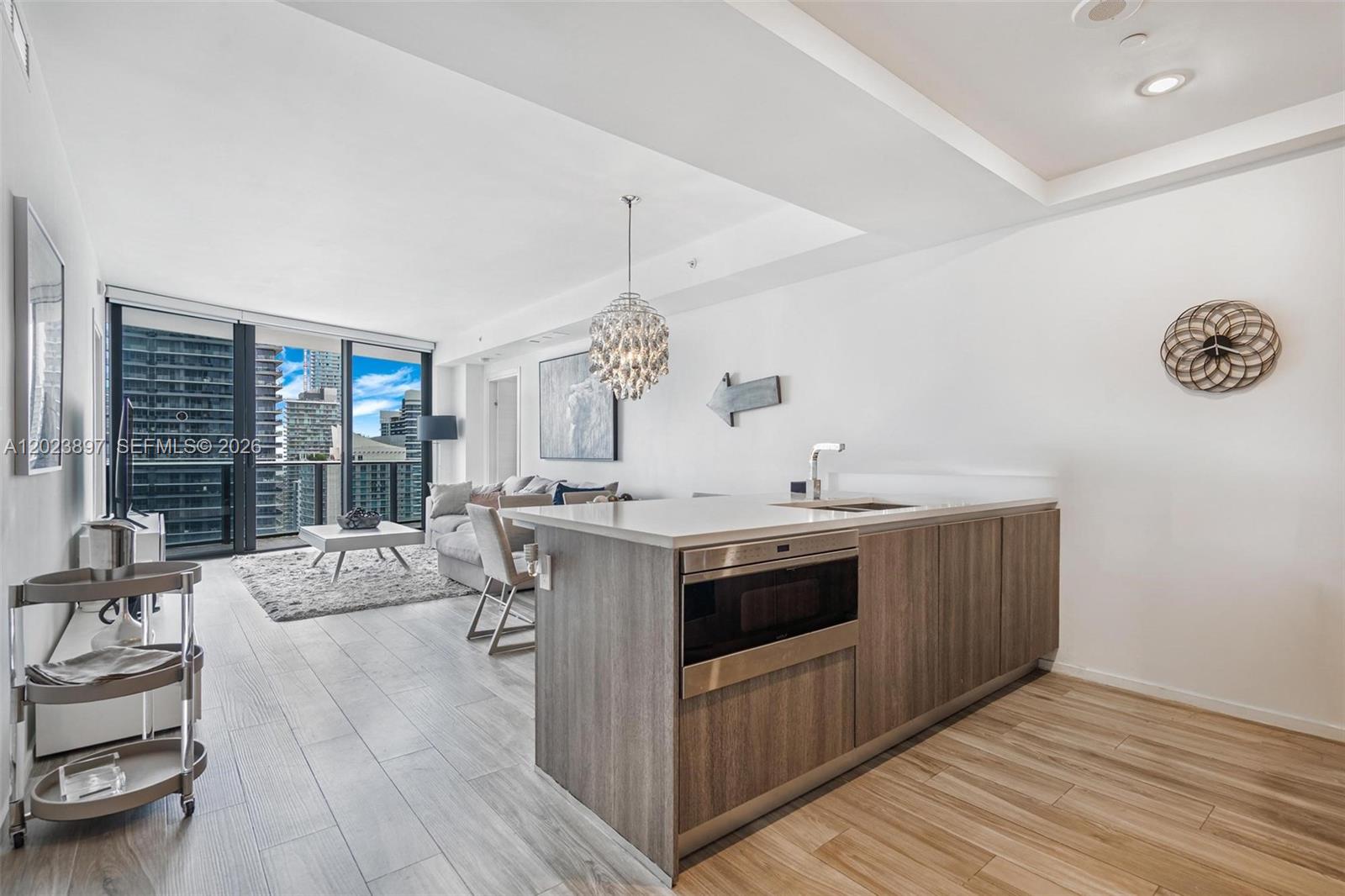 A high-rise balcony with a glass railing overlooks a dense city skyline and the ocean — 801 S Miami Ave # 4302, Miami FL 33130, MIAMI, FL