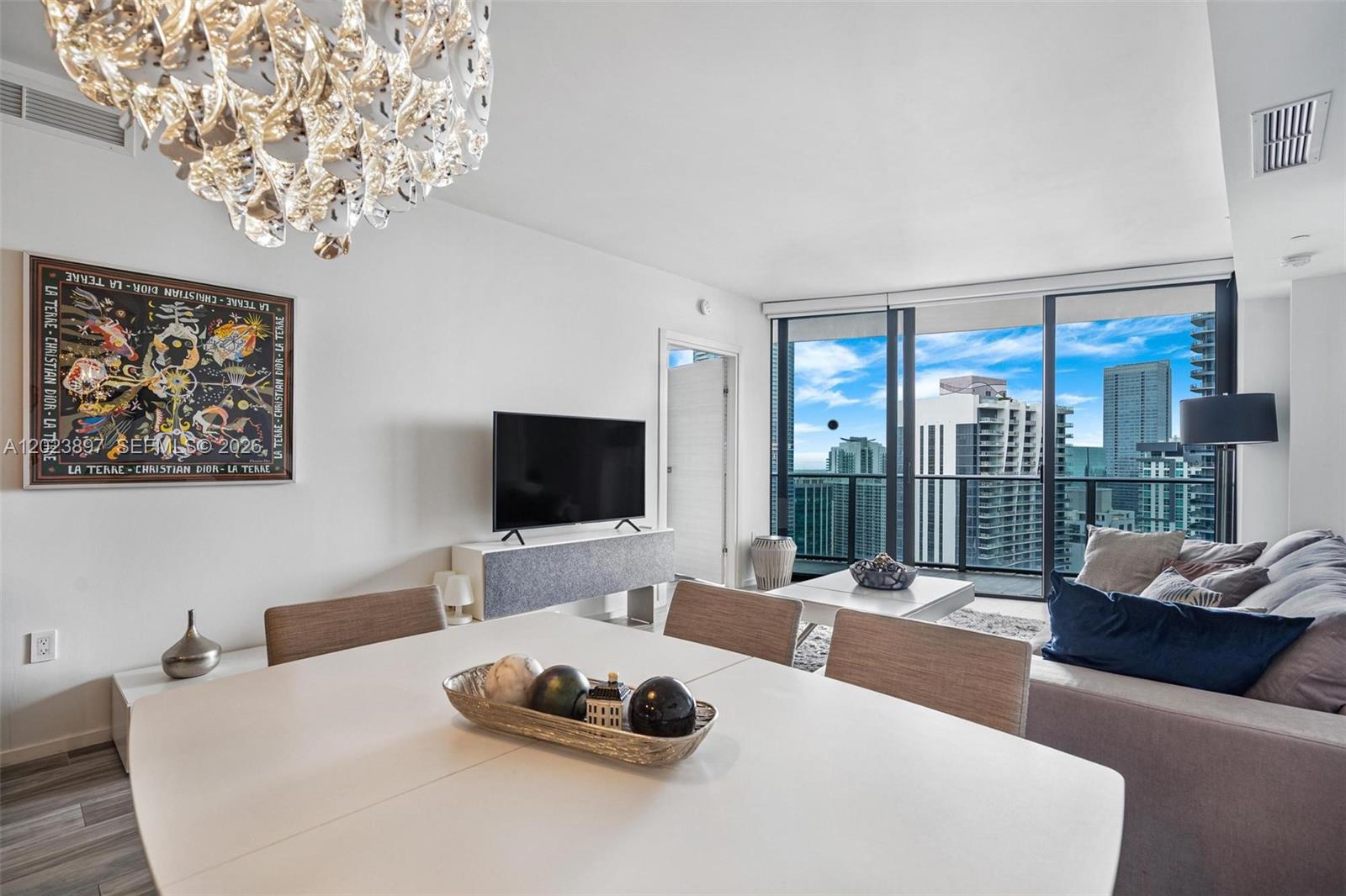 A modern kitchen with wood-grain cabinetry and a central island overlooks a bright living area — 801 S Miami Ave # 4302, Miami FL 33130, MIAMI, FL