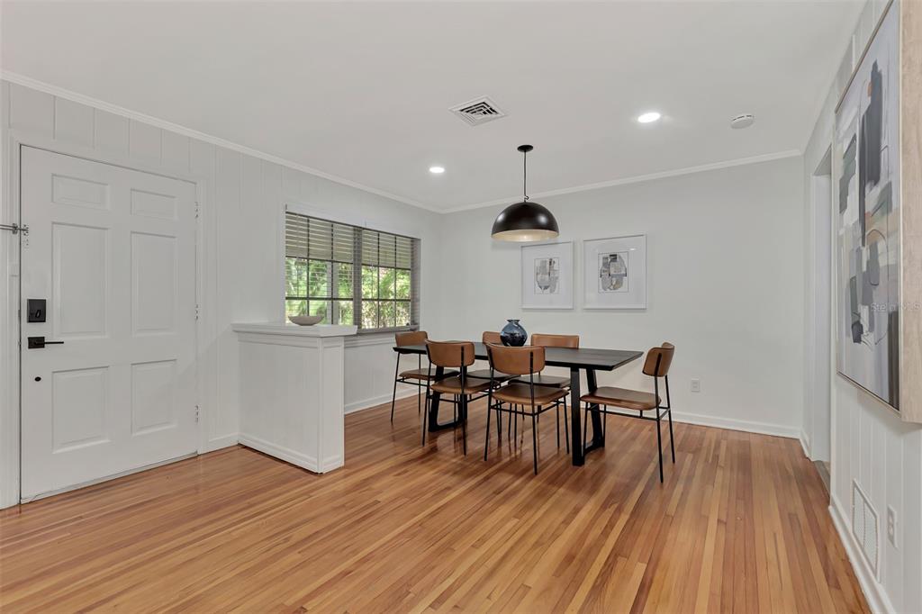A dining room with a dark table, leather chairs, hardwood floors, and a pendant light — 1726 FLOYD STREET, SARASOTA, FL