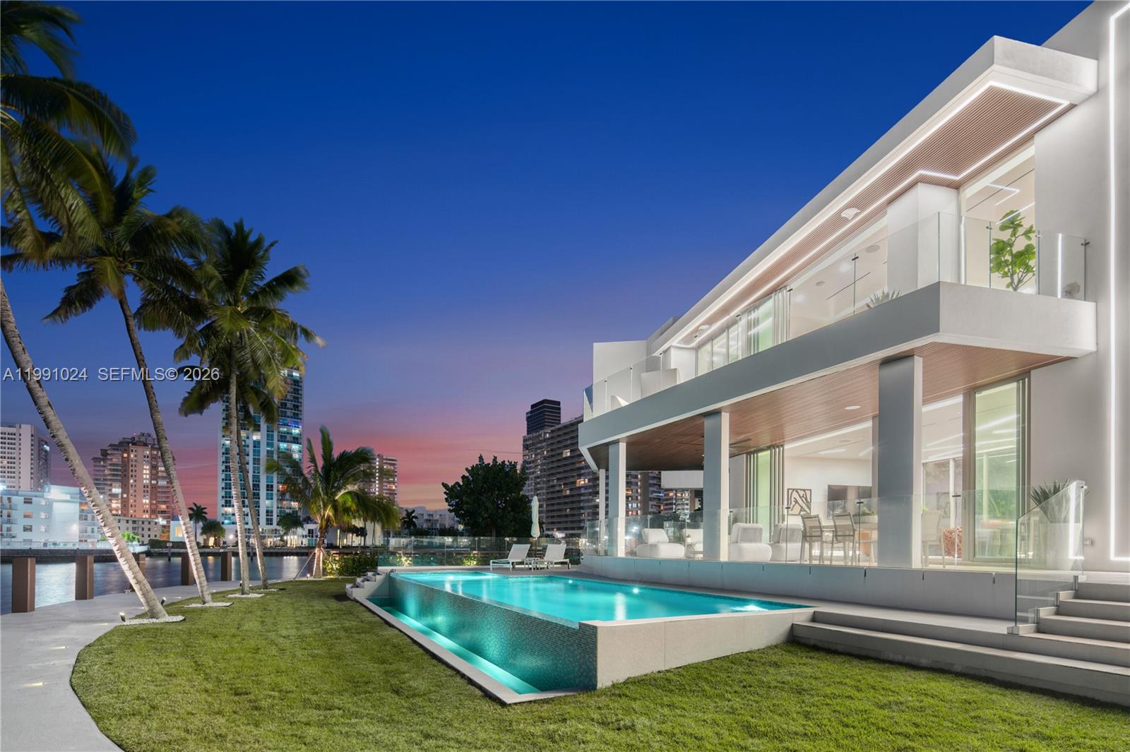A modern two-story house with a pool and palm trees at sunset — 501 Palm Dr, Hallandale Beach FL 33009, HALLANDALE BEACH, FL