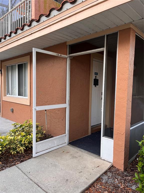 An exterior view of a building entrance with a screen door and a white door — 8304 WATERVIEW WAY UNIT 8304, WINTER HAVEN, FL