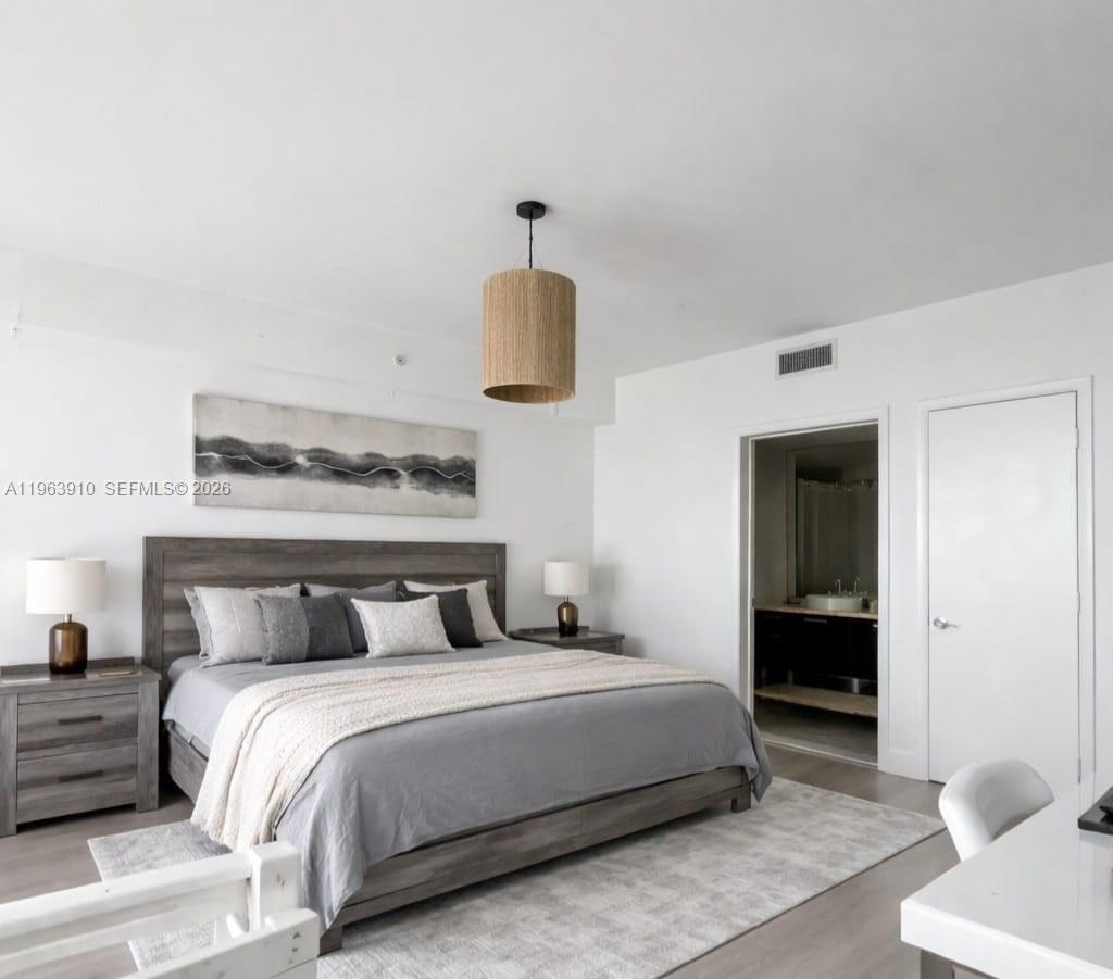 A high-ceilinged living room features floor-to-ceiling windows overlooking a parking lot and a Ferris wheel — 253 NE 2nd St # 433, Miami FL 33132, MIAMI, FL