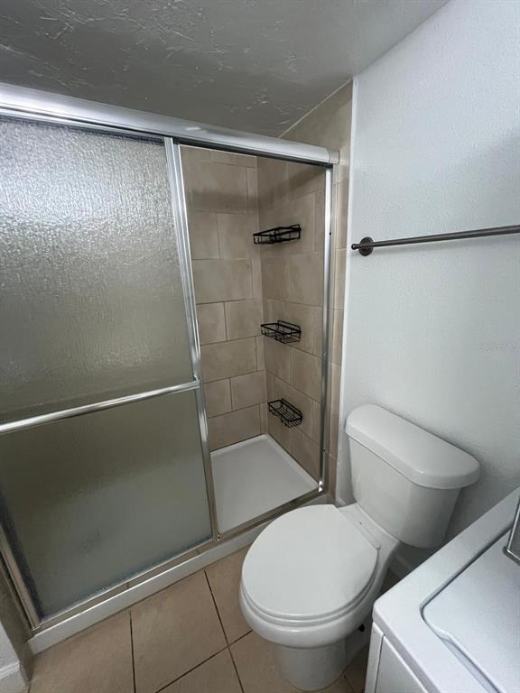 A bathroom features a tiled walk-in shower with sliding glass doors and a white toilet — 131 WATER FRONT WAY UNIT 150, ALTAMONTE SPRINGS, FL