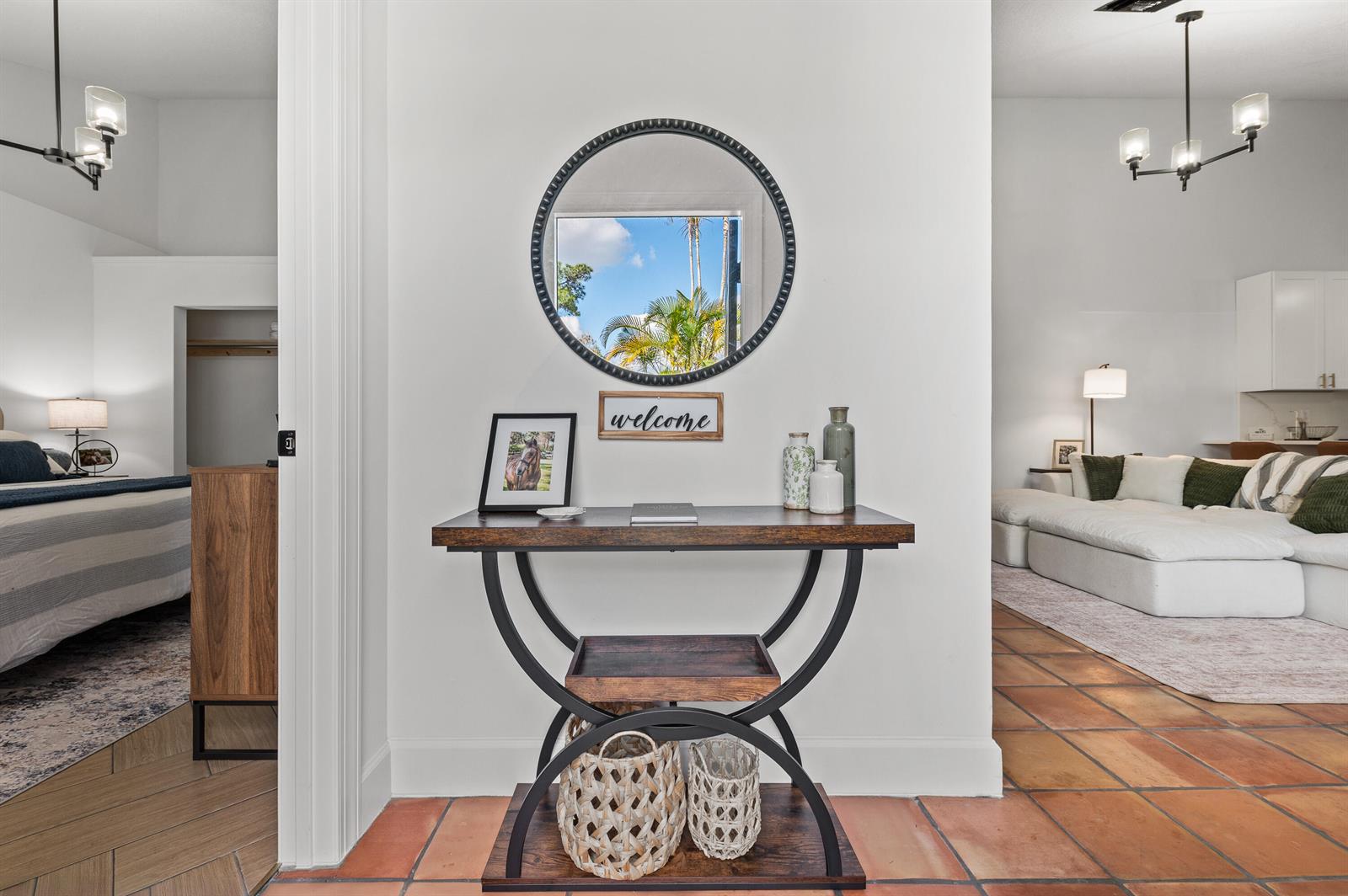 A console table with a mirror sits in a hallway between a bedroom and living room — 1277 Periwinkle Place, Wellington FL 33414, WELLINGTON, FL