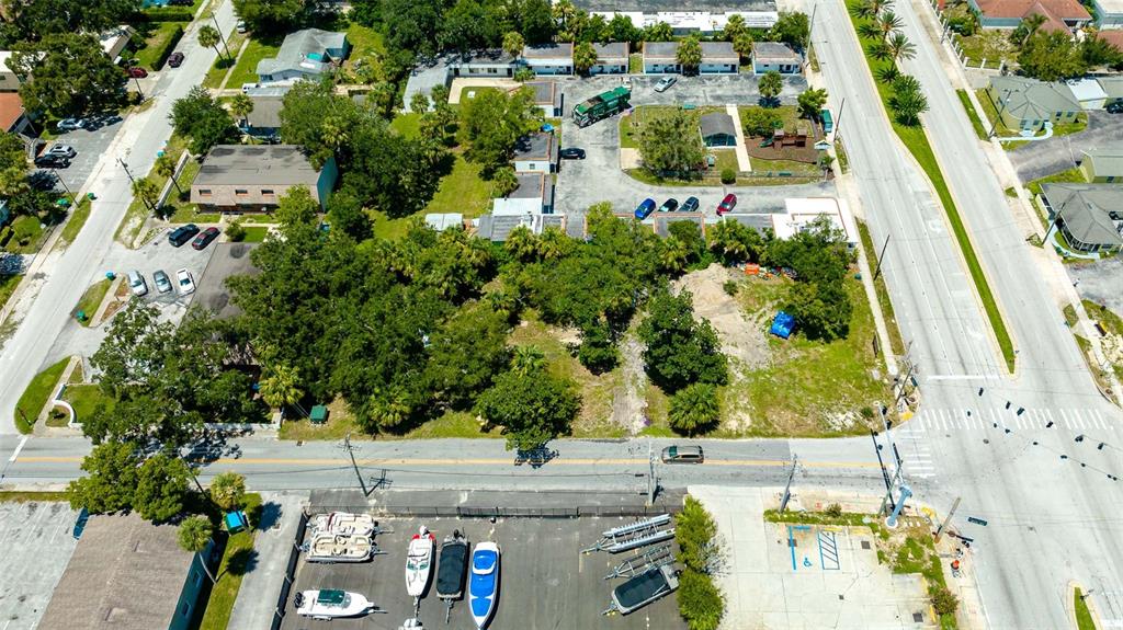 An aerial view shows a vacant lot surrounded by buildings, parking areas, and a road — 000 RIDGEWOOD AVENUE, HOLLY HILL, FL