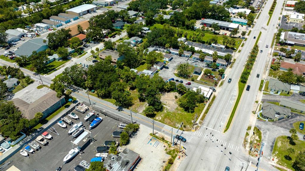 An aerial view shows a boat storage lot, a vacant grassy area, and nearby commercial buildings — 000 RIDGEWOOD AVENUE, HOLLY HILL, FL