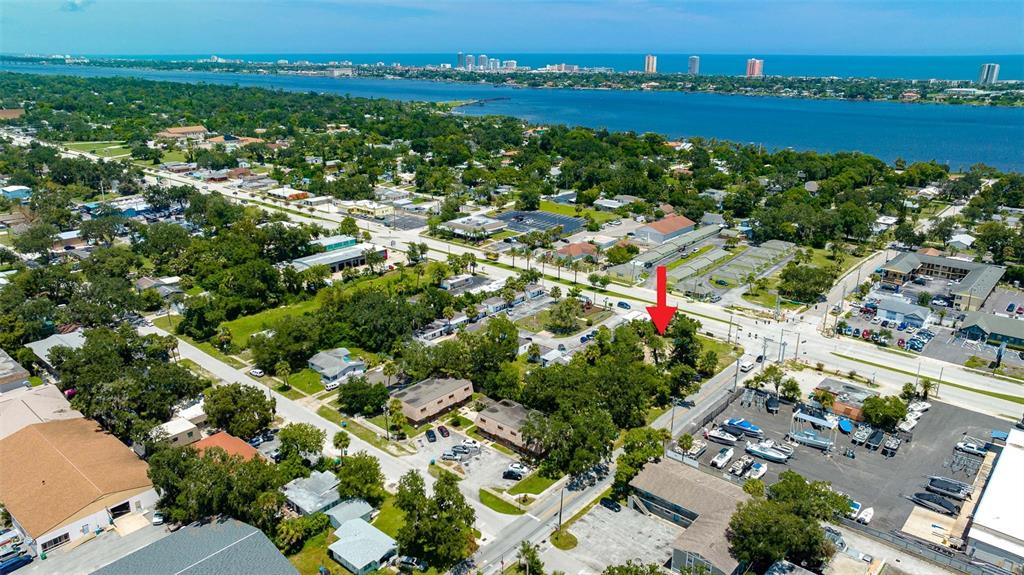 An aerial view shows a residential area with a red arrow pointing toward a property — 000 RIDGEWOOD AVENUE, HOLLY HILL, FL