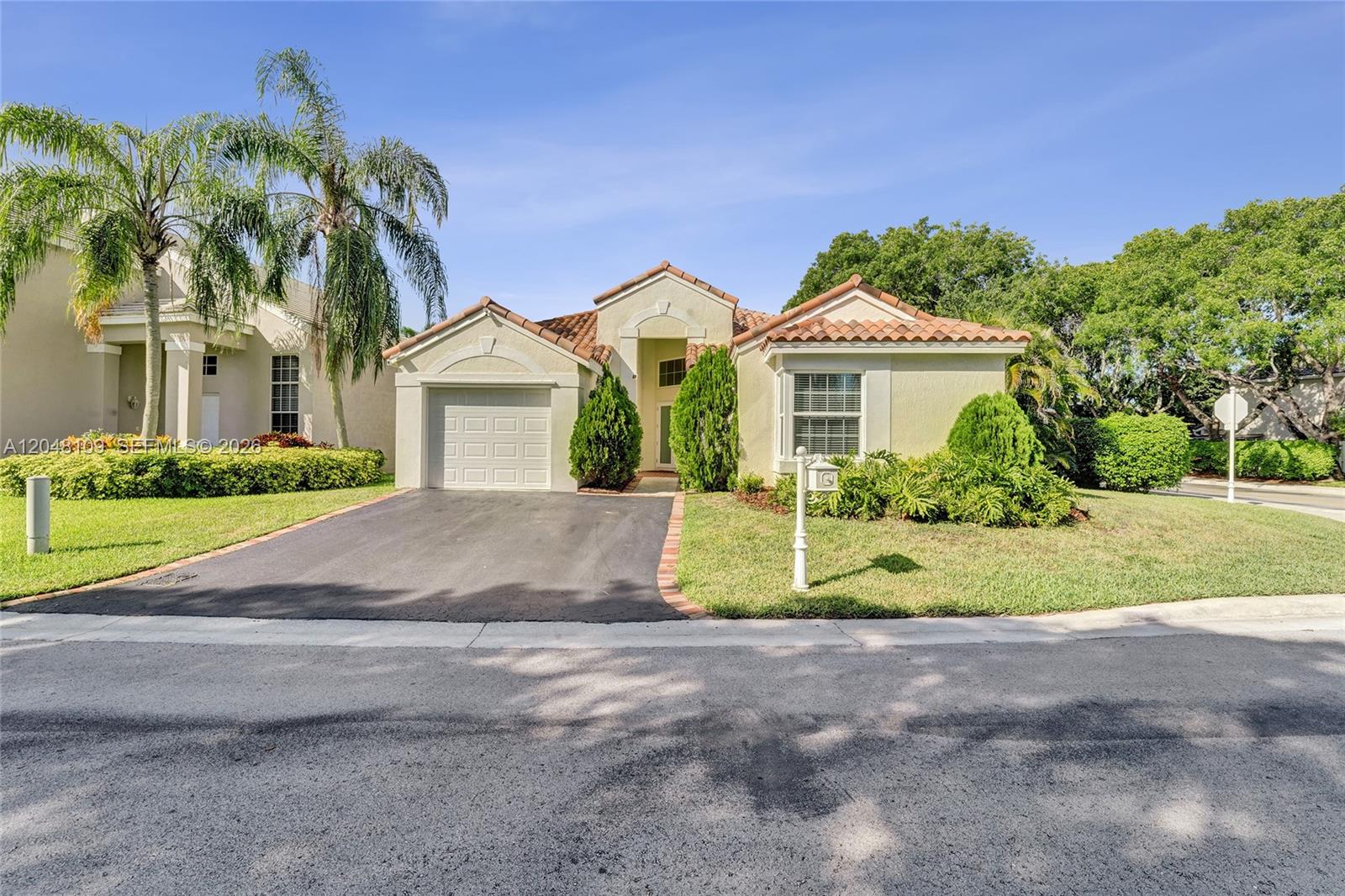 A single-story house with a tile roof, a one-car garage, and a paved driveway — 507 Bridgeton Rd, Weston FL 33326, WESTON, FL