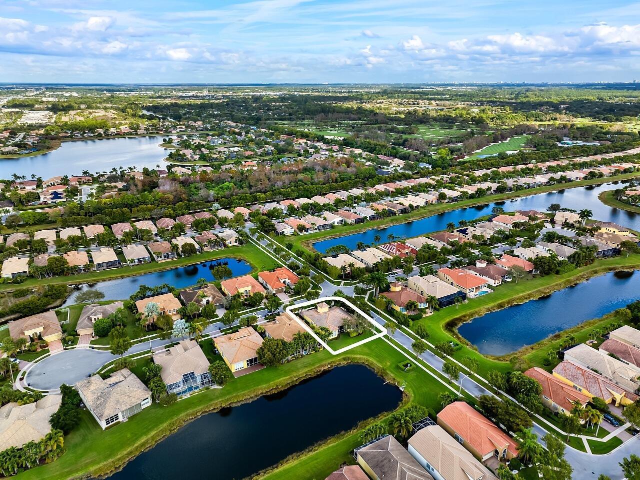 An aerial view of a suburban neighborhood featuring houses surrounding several small lakes — 9724 Via Grandezza W, Wellington FL 33411, WELLINGTON, FL