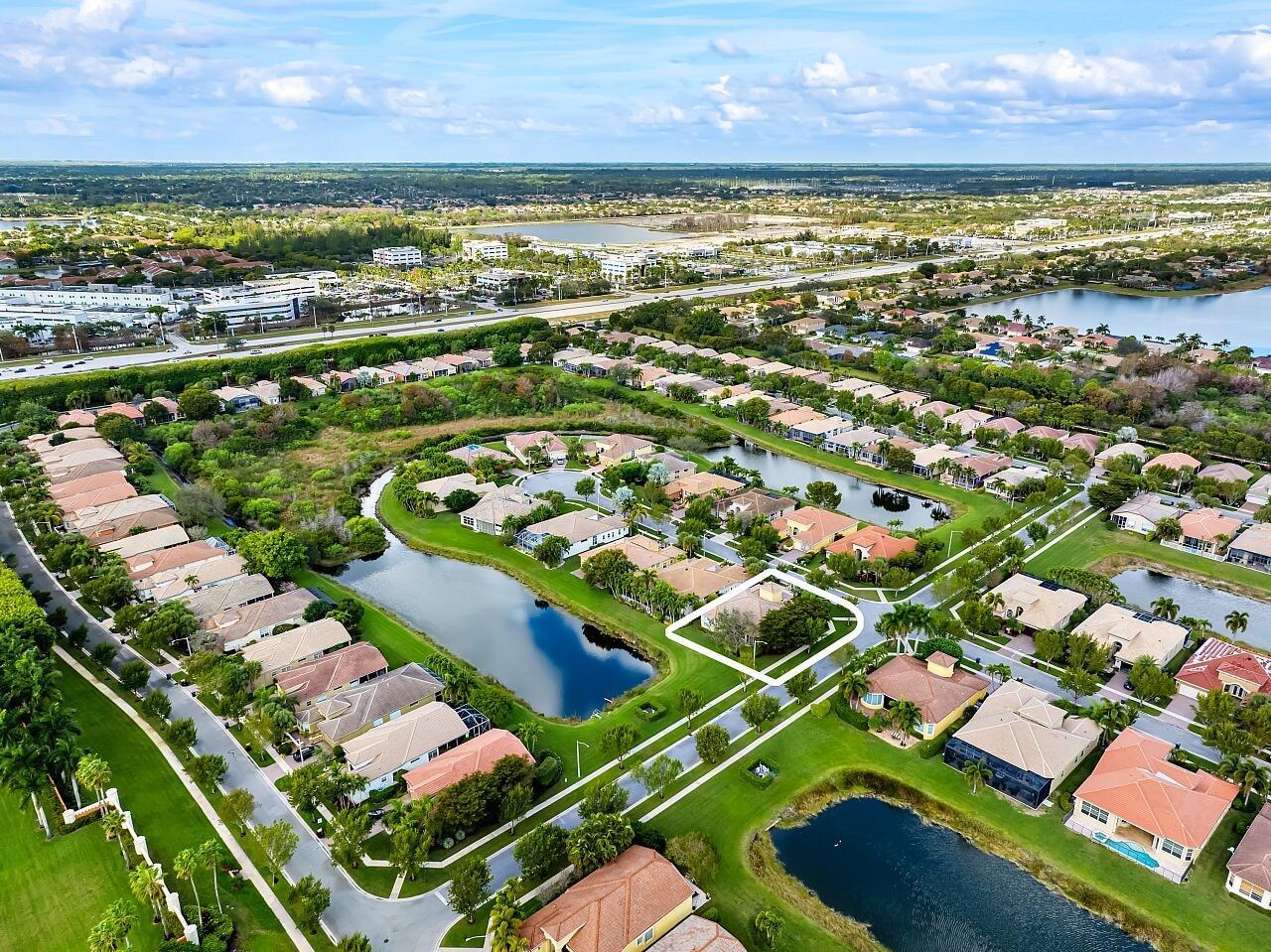 An aerial view of a suburban neighborhood featuring houses, ponds, and green spaces — 9724 Via Grandezza W, Wellington FL 33411, WELLINGTON, FL