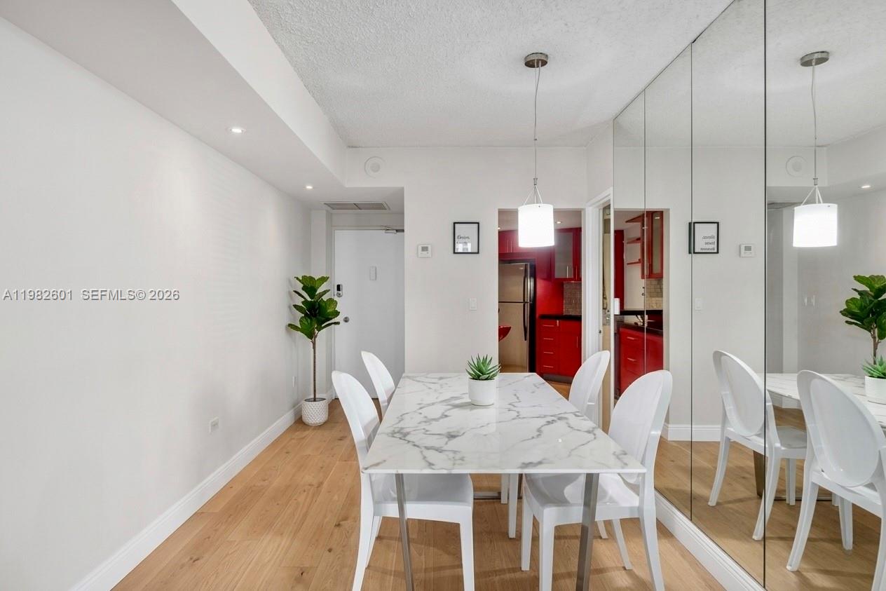 A dining area features a marble-topped table, white chairs, and a mirrored wall — 801 Brickell Bay Dr # 1262, Miami FL 33131, MIAMI, FL