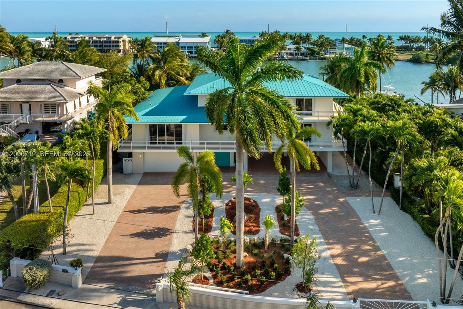 An elevated house with a teal metal roof sits behind a landscaped brick driveway — 137 Sapodilla Dr, Islamorada FL 33036, ISLAMORADA, FL
