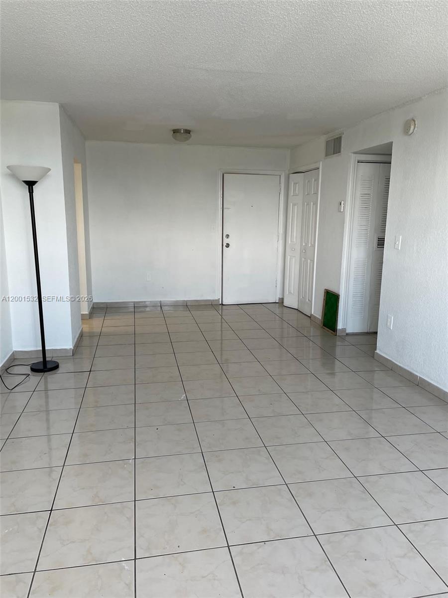 An empty room features white walls, a tiled floor, and several closed white doors — 666 W 81st St # 407, Hialeah FL 33014, HIALEAH, FL