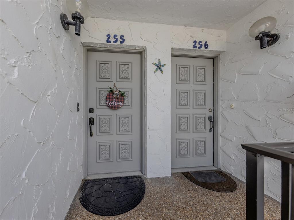 Two gray entry doors with house numbers 255 and 256 set in a textured white wall — 1555 TARPON CENTER DRIVE UNIT 255, VENICE, FL