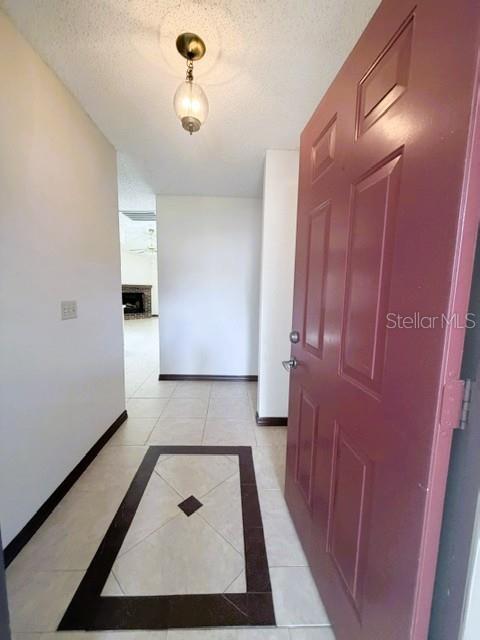 An entryway features a maroon door, tiled floor with a decorative inlay, and a light fixture — 5184 LAZY OAKS DRIVE, WINTER PARK, FL