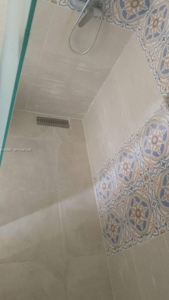 A shower stall features light-colored wall tiles, a decorative patterned border, and a linear drain — 1 cap cana # 0, FL
