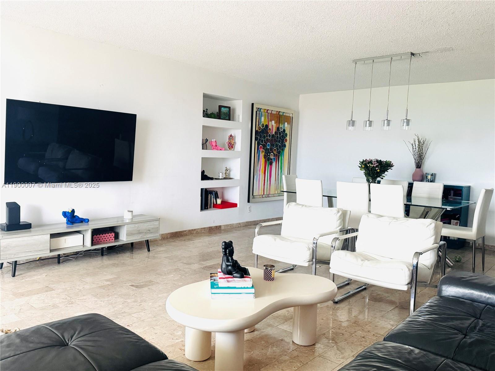 A living and dining area features white walls, tile floors, and modern furniture — 600 Three Islands Blvd # 1206, Hallandale Beach FL 33009, HALLANDALE BEACH, FL
