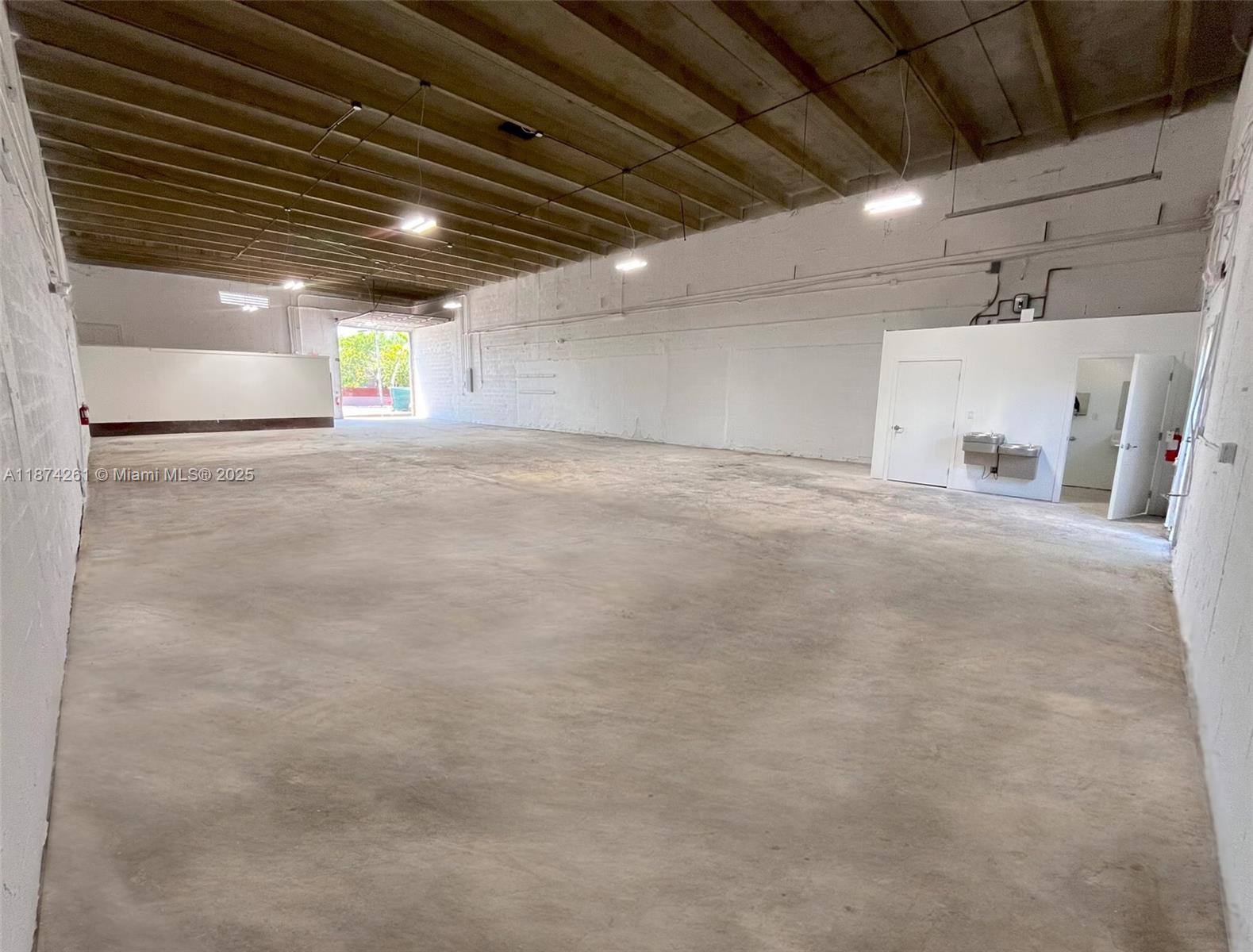 An empty industrial warehouse space features concrete floors, white walls, and exposed ceiling beams — 1401 NW 23rd St, Miami FL 33142, MIAMI, FL