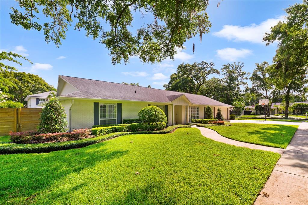 A single-story white brick house with a manicured lawn and a curved concrete walkway — 1615 KING ARTHUR CIRCLE, MAITLAND, FL