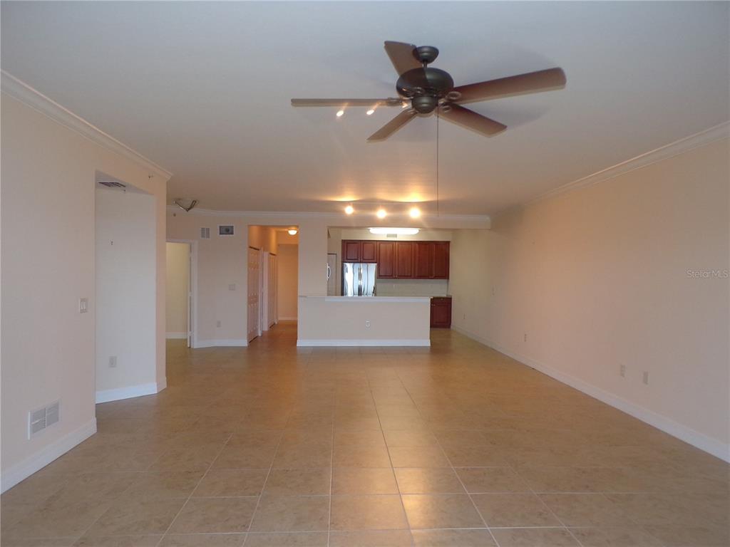 An open-concept living area features tile flooring, a ceiling fan, and a kitchen with cabinets — 93 VIVANTE BOULEVARD UNIT 9333, PUNTA GORDA, FL