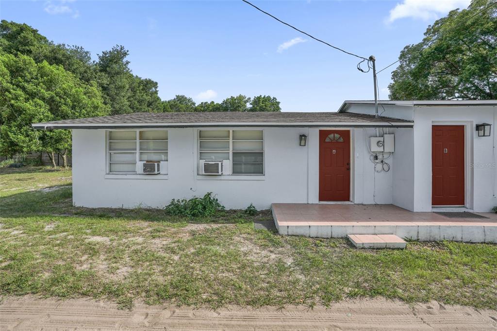 A single-story white house with two red doors labeled A and B — 1460 MARVIN C ZANDERS AVENUE UNIT A, APOPKA, FL