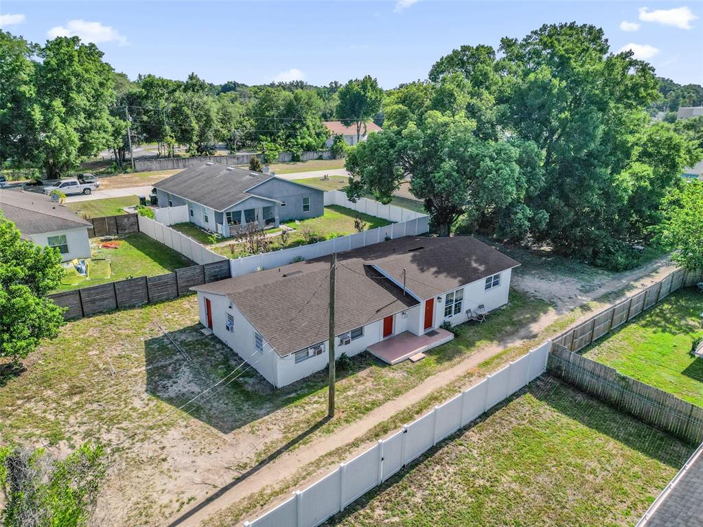 An aerial view shows a single-story multi-unit residential building with white walls and brown roofs — 1460 MARVIN C ZANDERS AVENUE UNIT A, APOPKA, FL