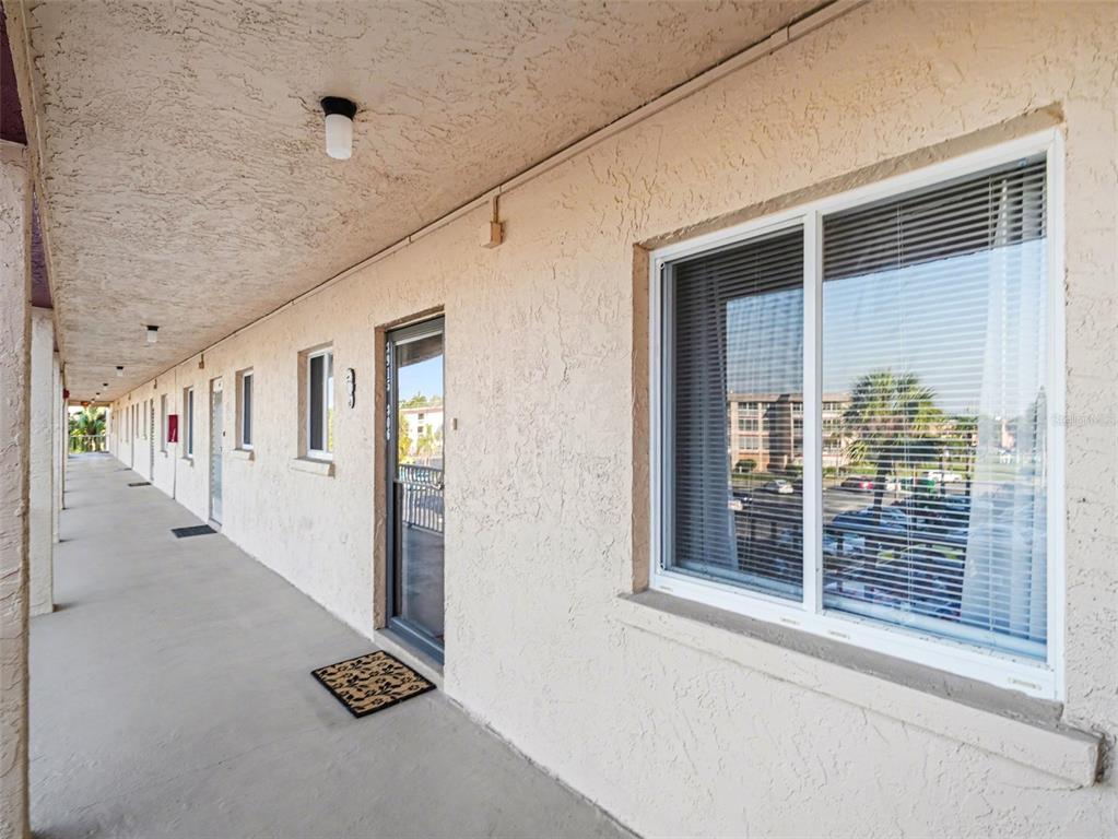 A multi-story apartment building with balconies and a paved parking lot in the foreground — 3915 LAKE BAYSHORE DRIVE UNIT 306, BRADENTON, FL