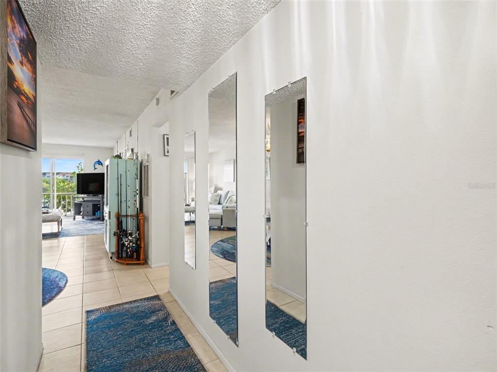 An exterior view of an apartment building walkway with a row of doors and windows — 3915 LAKE BAYSHORE DRIVE UNIT 306, BRADENTON, FL