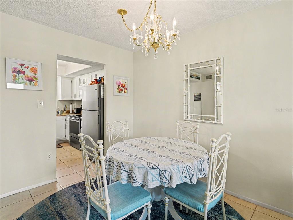 A kitchen features white cabinets, stainless steel appliances, and speckled laminate countertops — 3915 LAKE BAYSHORE DRIVE UNIT 306, BRADENTON, FL