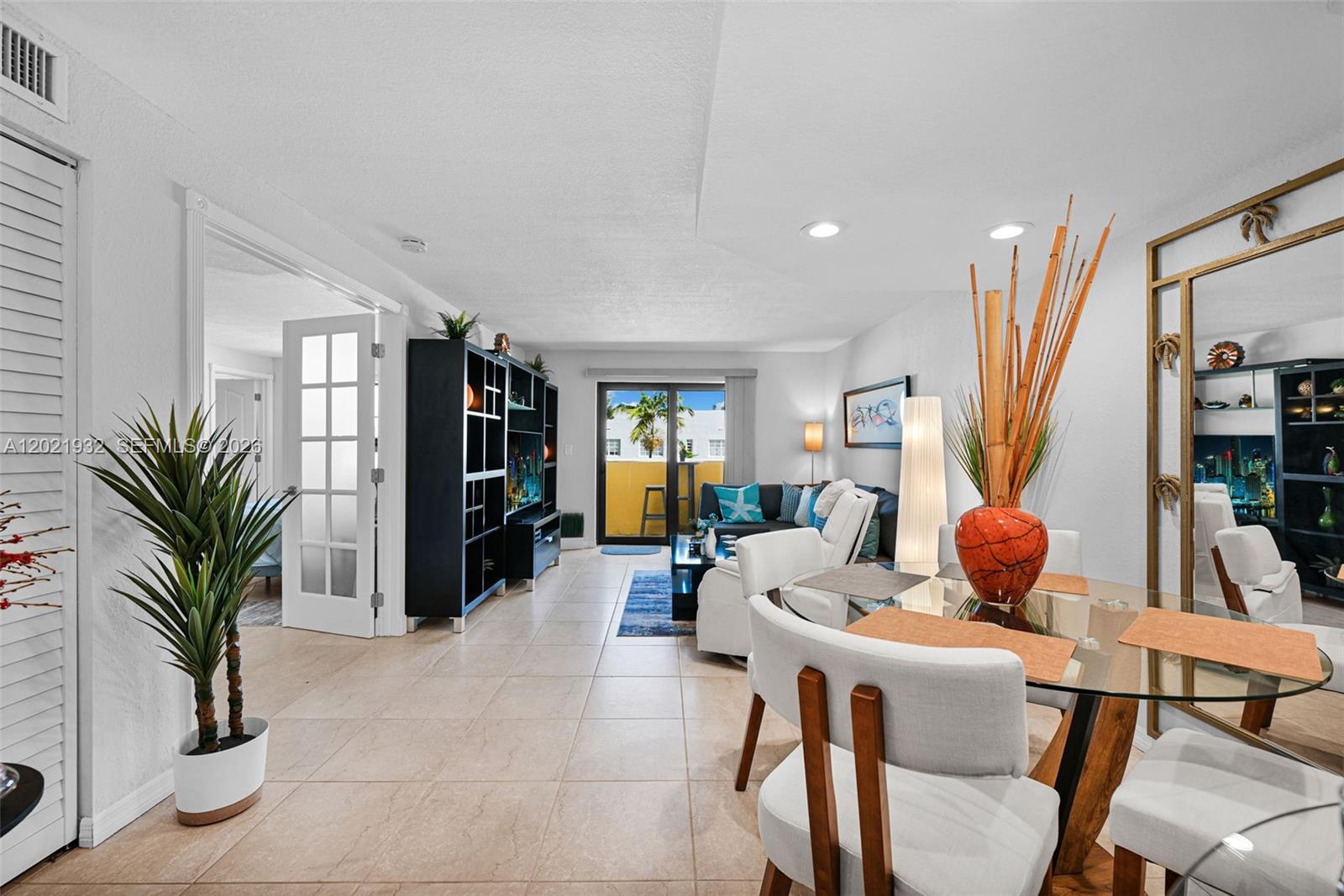 A living and dining area features tile flooring, a glass table, and a balcony view — 1334 Collins Ave # 403, Miami Beach FL 33139, MIAMI BEACH, FL