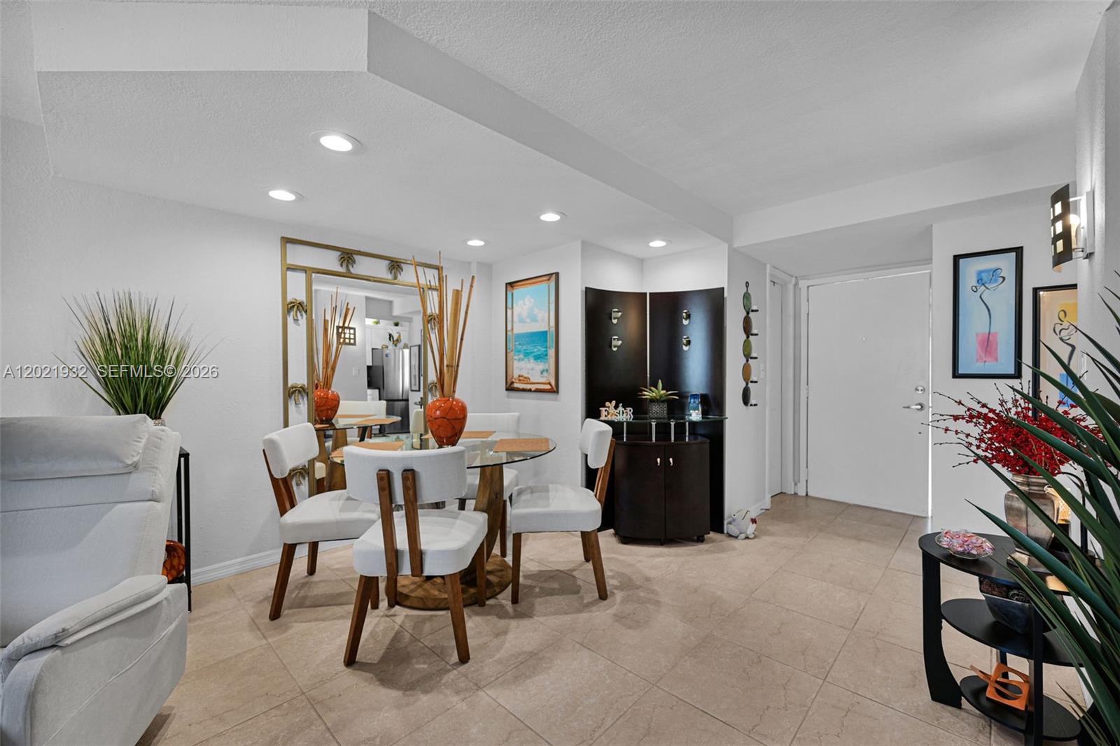 A dining area features a glass-topped table, white chairs, a mirror, and tile flooring — 1334 Collins Ave # 403, Miami Beach FL 33139, MIAMI BEACH, FL