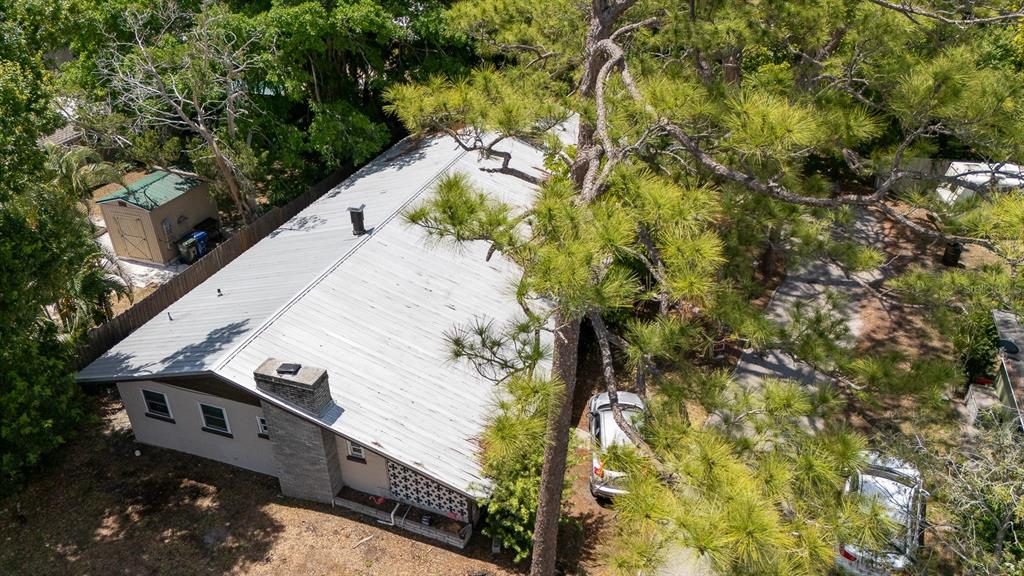 An aerial view shows a house with a metal roof, brick chimney, and surrounding trees — 2110 PALM TERRACE, SARASOTA, FL