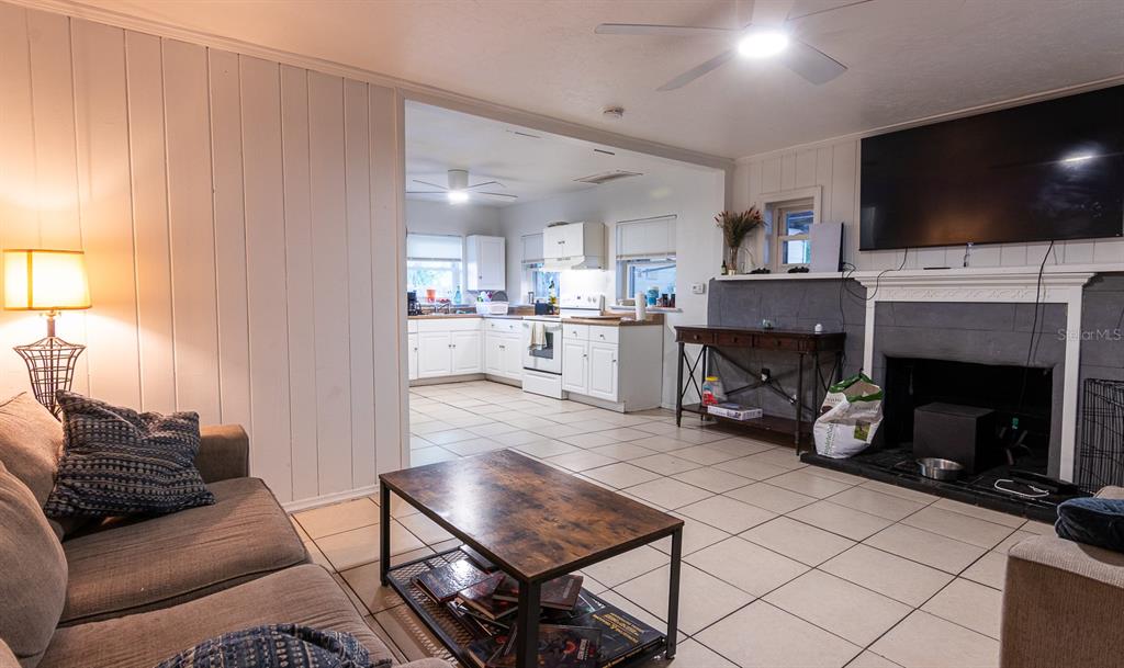 A living room with a fireplace and tile floors opens into a white kitchen — 2110 PALM TERRACE, SARASOTA, FL