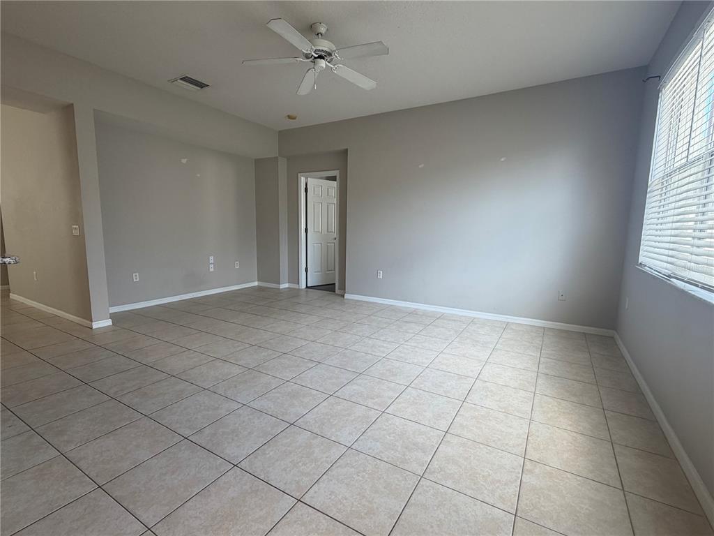 A kitchen features wood cabinets, white appliances, a granite-topped island, and tile flooring — 13508 BLUE SUNFISH COURT, RIVERVIEW, FL