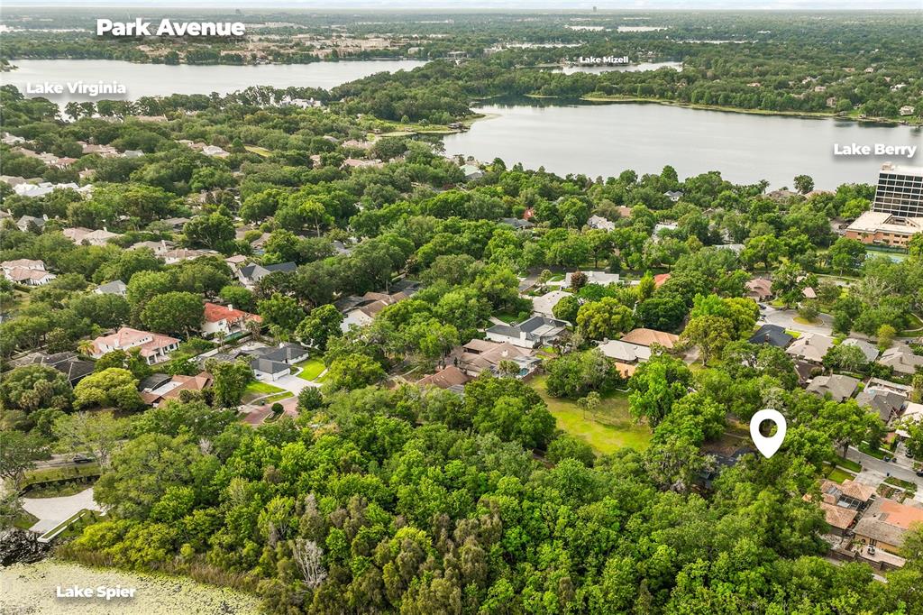 An aerial view shows a residential neighborhood with dense trees and several nearby lakes — JESSICA COURT, WINTER PARK, FL