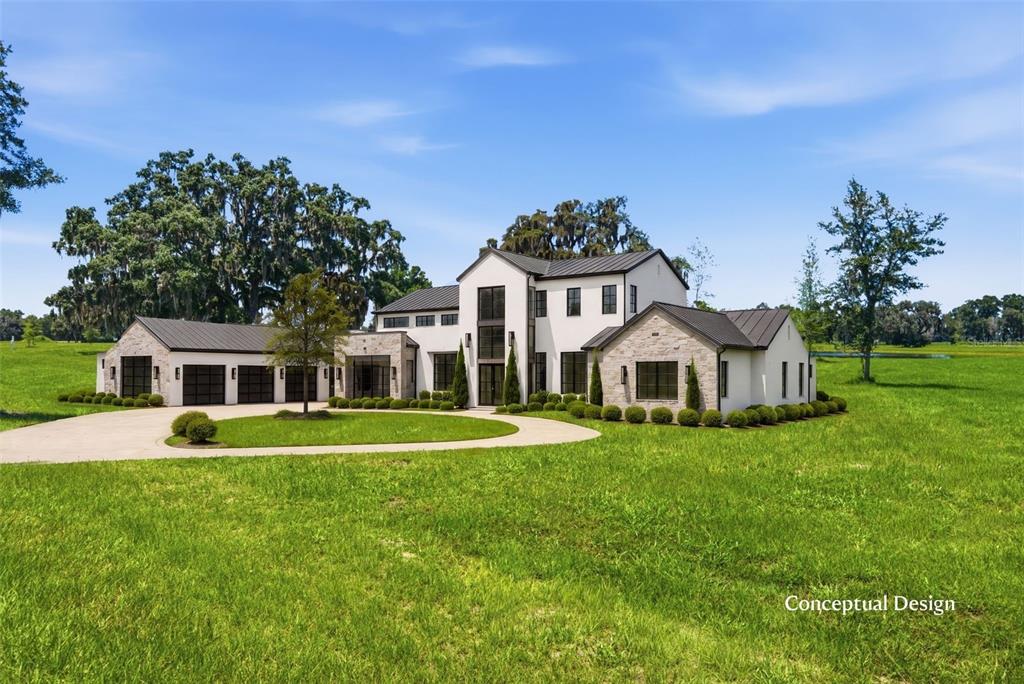 A rendering of a modern farmhouse with stone accents, a metal roof, and a circular driveway — TBD (Lot 22-W) SW 138TH LOOP, DUNNELLON, FL