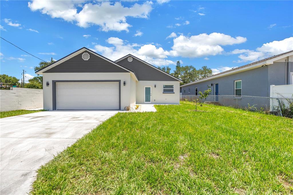 The exterior of a modern, single-story house features a two-car garage and a front lawn — 1827 16TH STREET S, ST PETERSBURG, FL