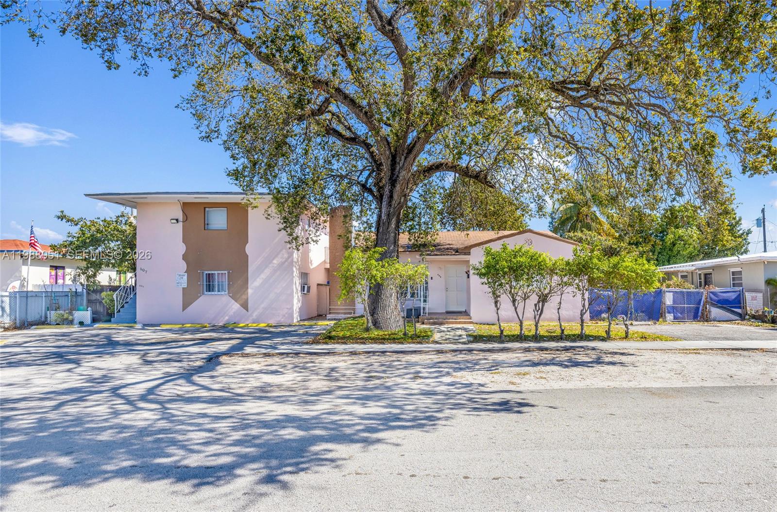 A two-story building and a single-story house stand behind a large tree — 605 NW 34th Ave, Miami FL 33125, MIAMI, FL