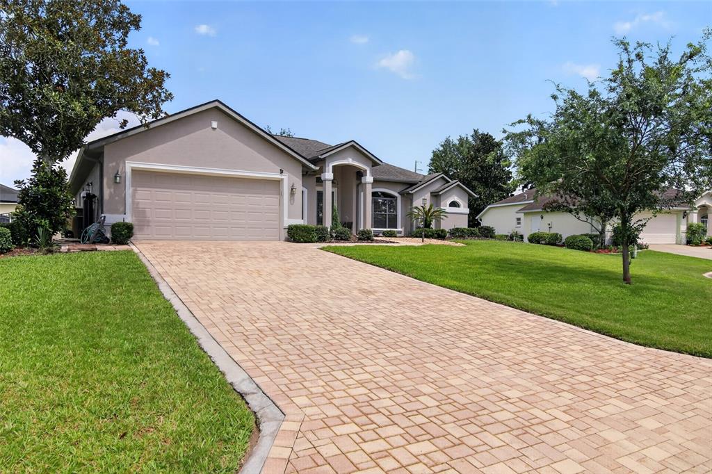A single-story house with a beige stucco exterior, a paved driveway, and a green lawn — 6535 SW 51ST TERRACE, OCALA, FL