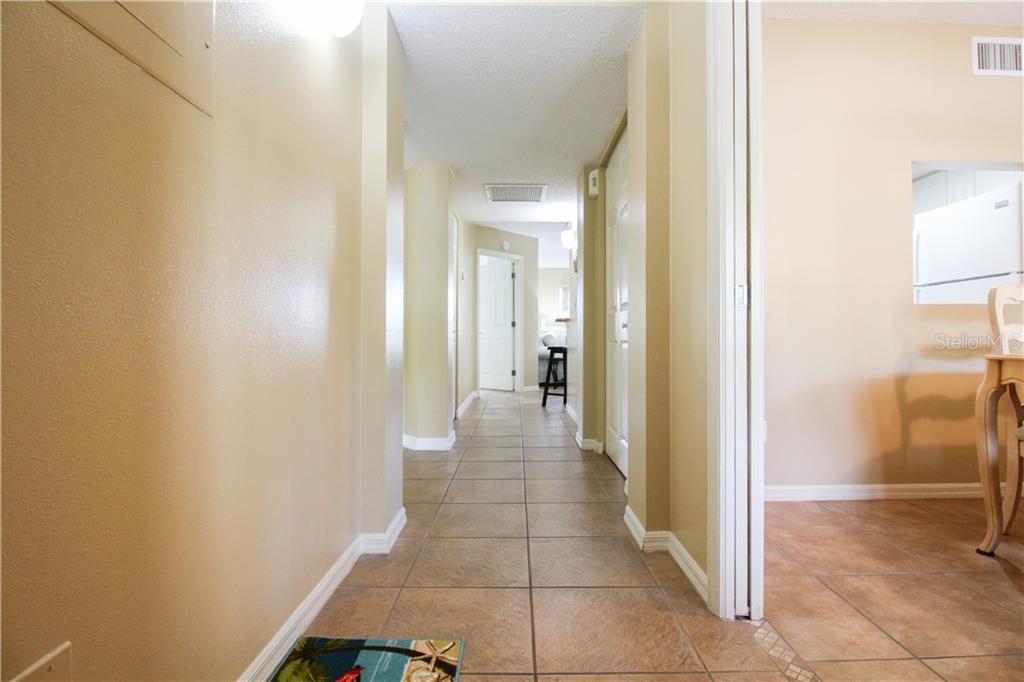 A tiled hallway leads past a dining area toward a bedroom door — 4457 45TH AVENUE W UNIT 110, BRADENTON, FL