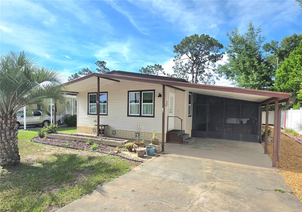 A single-story house with light siding, a screened-in porch, and a concrete driveway — 37408 MARTA AVENUE, ZEPHYRHILLS, FL