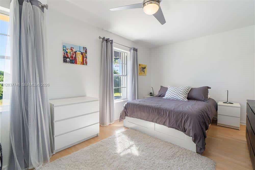 A bedroom features a bed with grey bedding, a white dresser, and a ceiling fan — 234 Waterside Dr # 234, Hypoluxo FL 33462, HYPOLUXO, FL