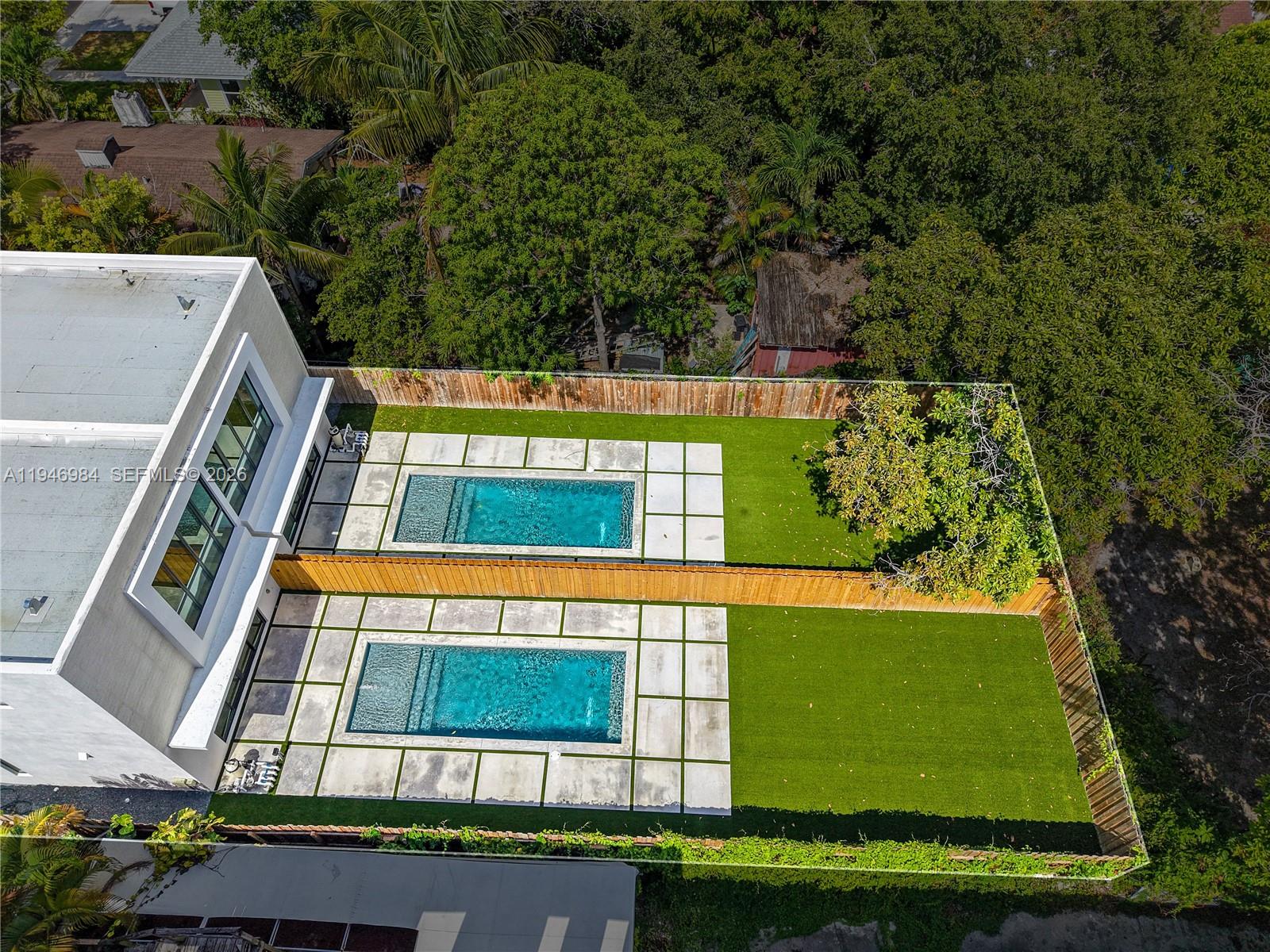 An aerial view shows two adjacent backyards, each featuring a rectangular swimming pool and artificial turf — 223 NW 51st St, Miami FL 33127, MIAMI, FL
