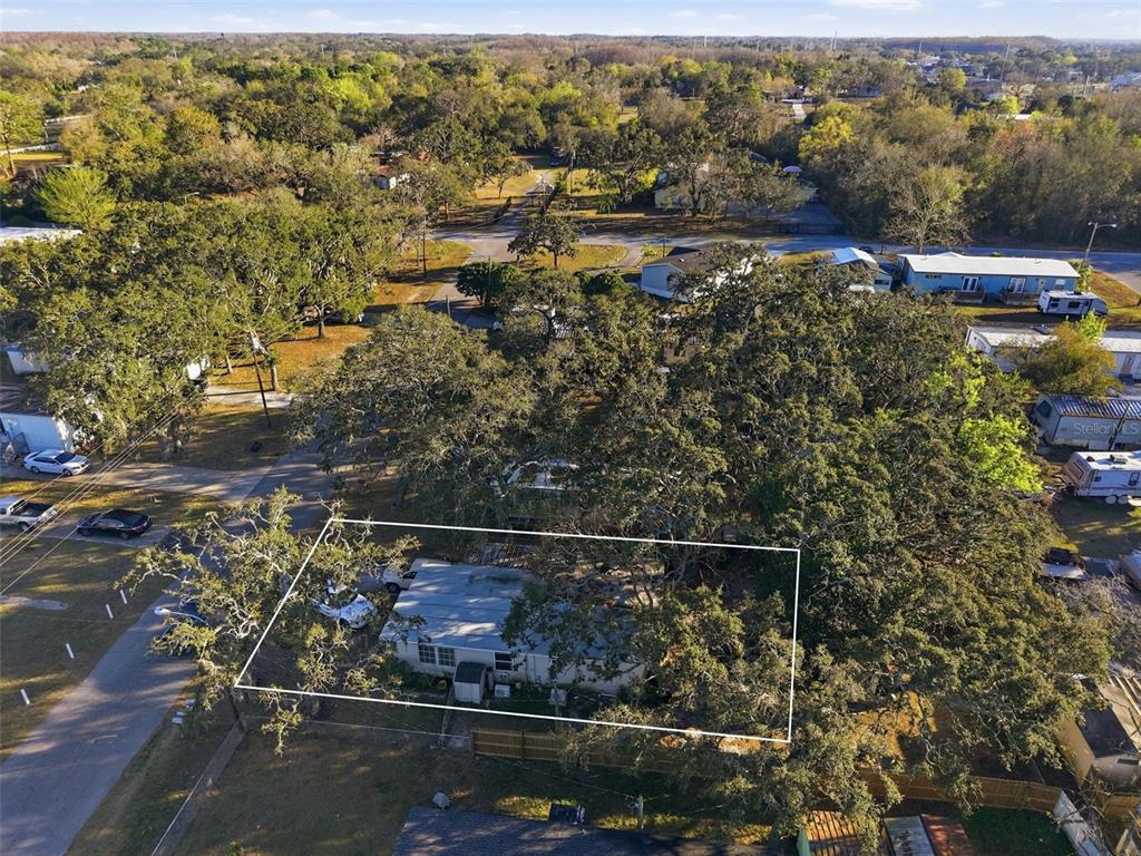 An aerial view shows a single-story house surrounded by mature trees within a fenced lot — 11311 ALTOONA AVENUE, NEW PORT RICHEY, FL