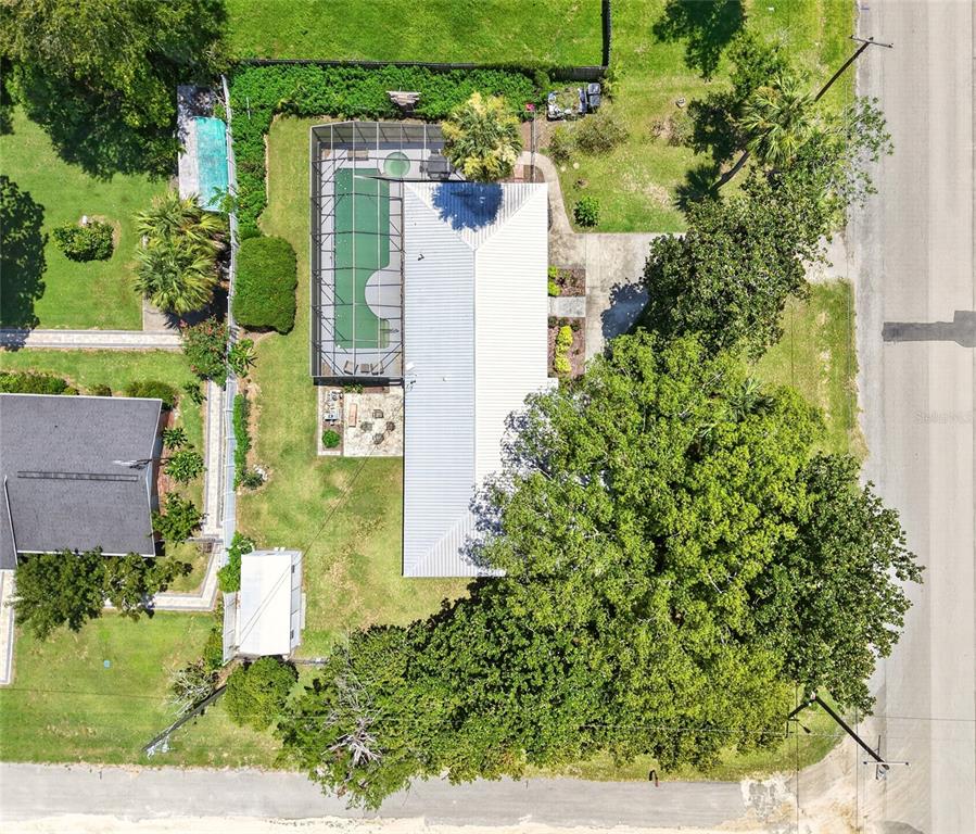 An aerial view shows a house with a screened-in pool and a large tree — 223 NW 7TH STREET, WILLISTON, FL