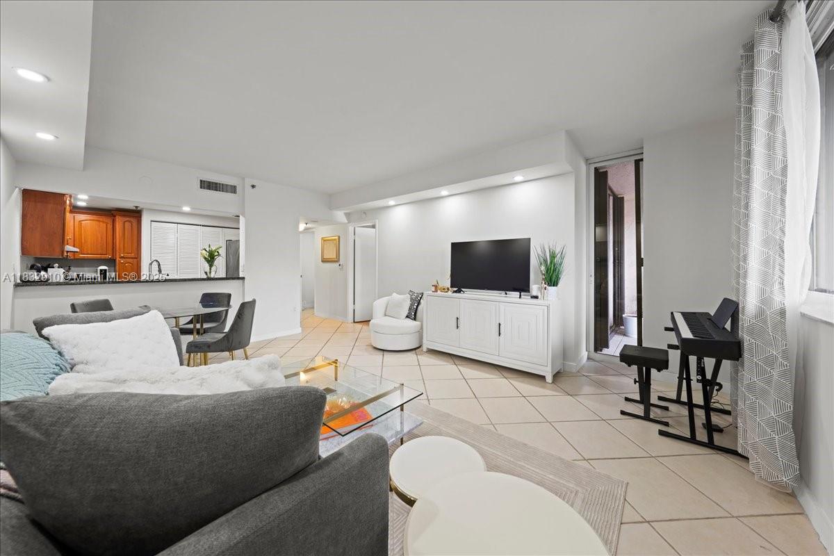 A living room features a gray sofa, a white media console, and a piano — 540 Brickell Key Dr # 412, Miami FL 33131, MIAMI, FL